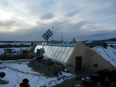 Earthship, outdoor view showing solar panels, outside of Taos, New Mexico.