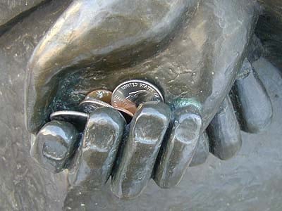 Coins in St. Francis' hands.