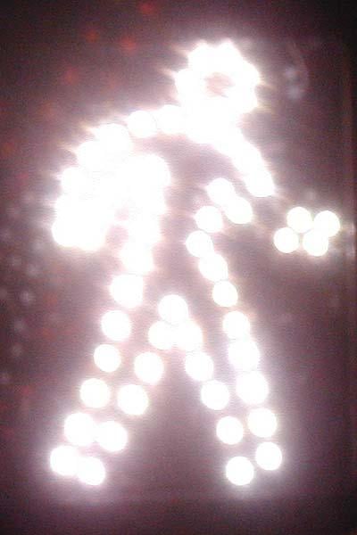 Traffic sign, illuminated with walking human image.