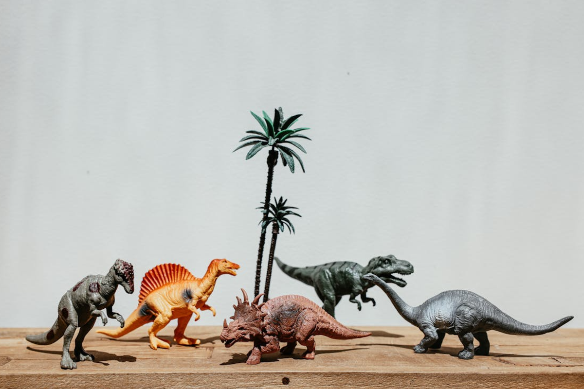 Image of toy dinosaurs and toy palm trees.