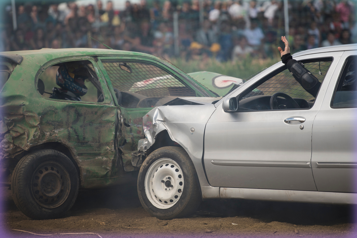 Photograph of two cars in a demolition derby smashing into each other.