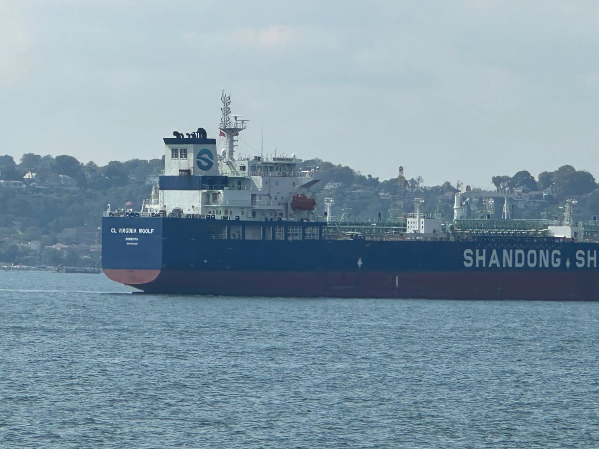 A big ocean going Shandong Shipping boat, but not container ship sized, with water in the foreground and hills behind. The vessel name is unreadable but could it be…