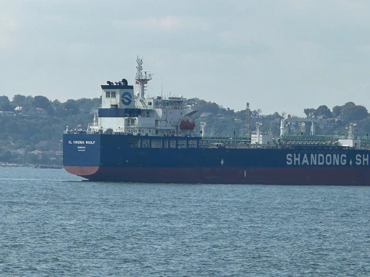 A big ocean going Shandong Shipping boat, but not container ship sized, with water in the foreground and hills behind. The vessel name is unreadable but could it be…