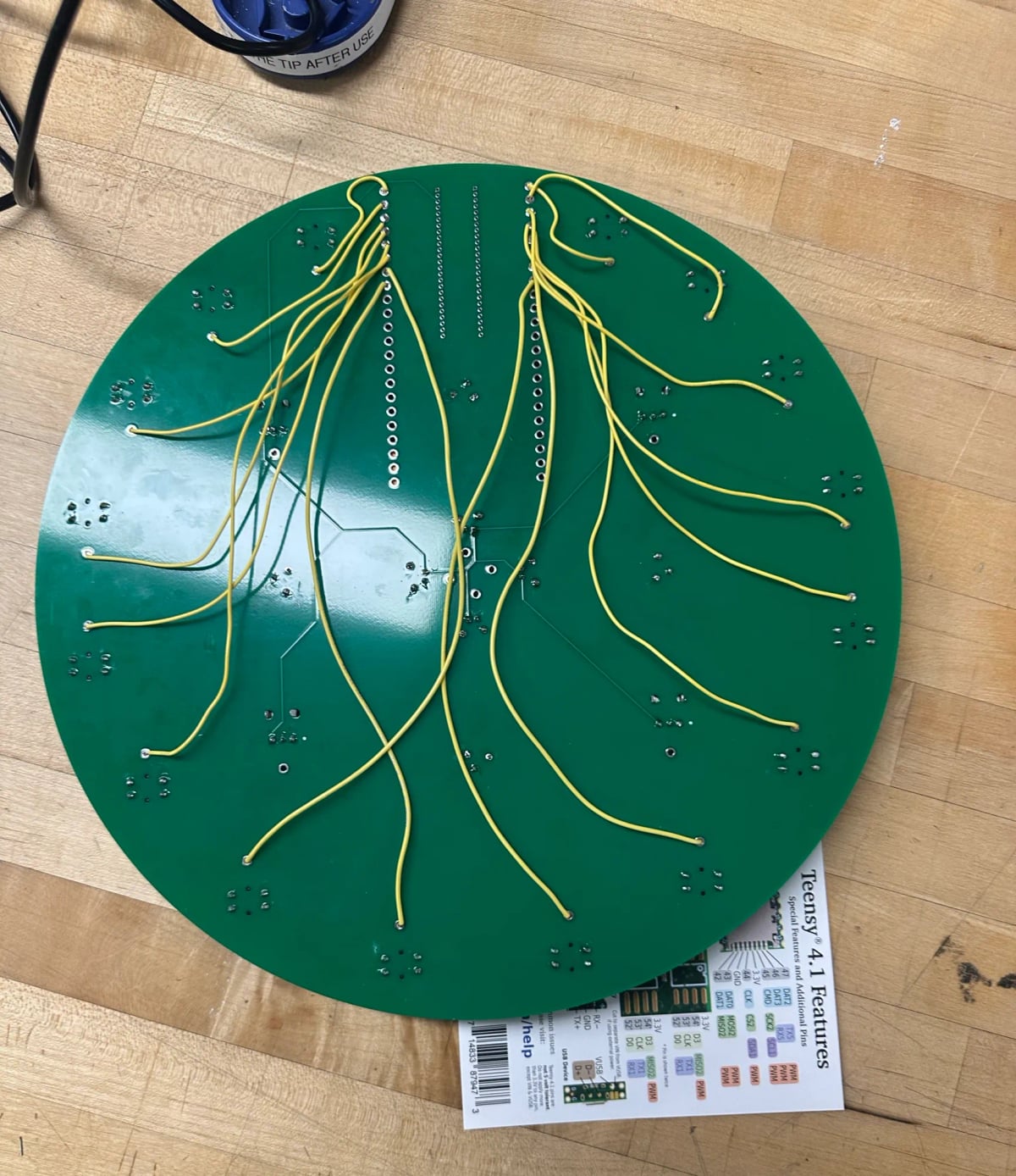 The back of the green clock shaped PCB with yellow wires but they’re a little loose and sloppy so it looks organic. Like a root system.