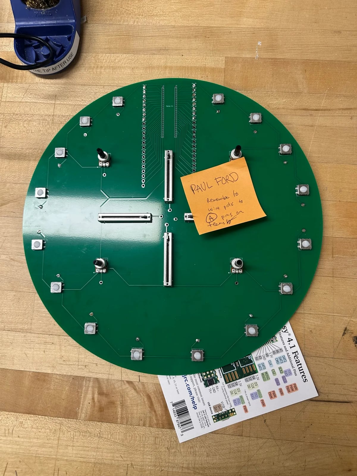 A round PCB with 16 switches four sliders and four knobs. Size of a clock.