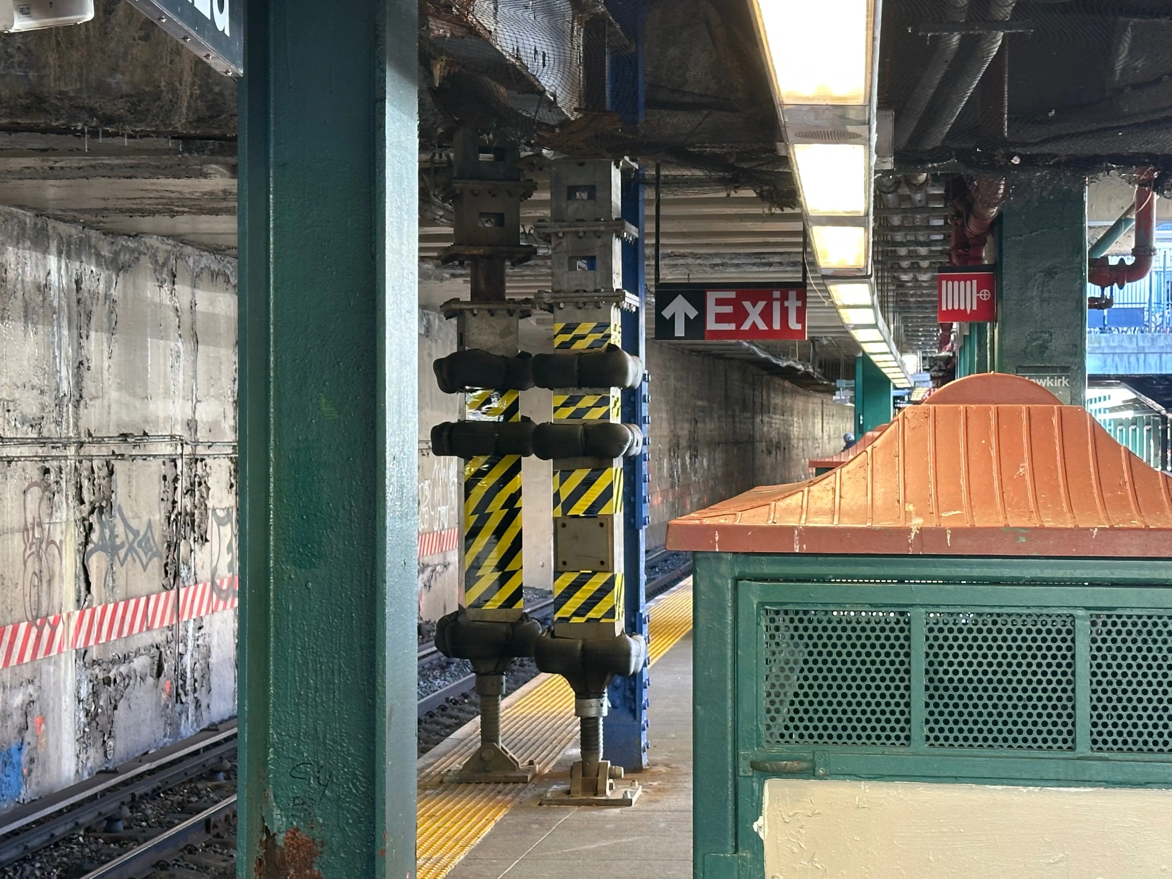 A subway stop in NYC. Two girders made up of odd shaped metal subsections extend platform to roof, wrapped in rubber numbers and zebra striped yellow and white tape. They taper to a huge screw at the bottom which is inserted into a broad flat metal foot, giving the whole thing an iron-giant-chicken-foot vibe. It does not in any way seem great or indicative of a robust and forward-looking attention to public infrastructure.